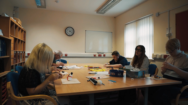 http://A%20group%20of%20people%20sit%20around%20a%20large%20table%20taking%20part%20in%20a%20craft%20activity,%20working%20with%20a%20variety%20of%20materials%20and%20equipment.